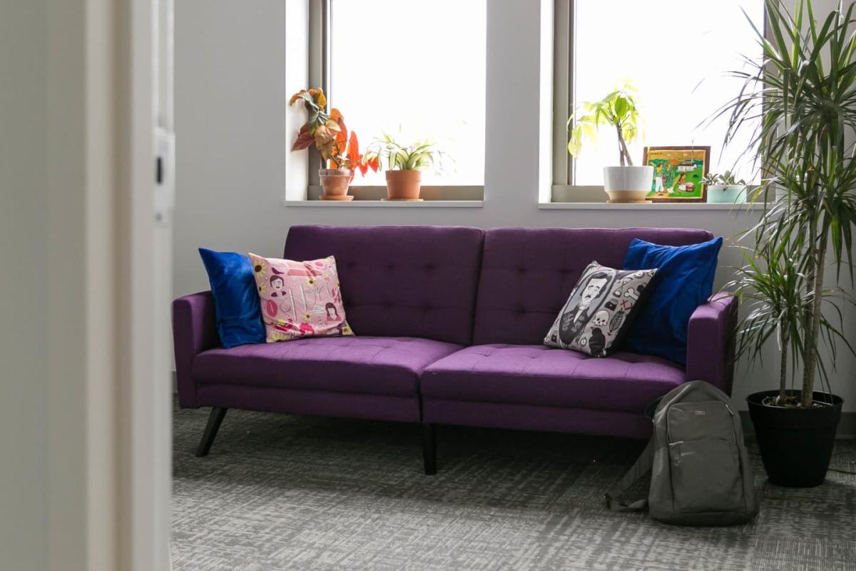 An small conference room windows and a purple couch with cushions