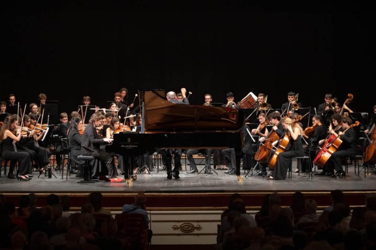 Pianist Anna Geniushene performing with an orchestra