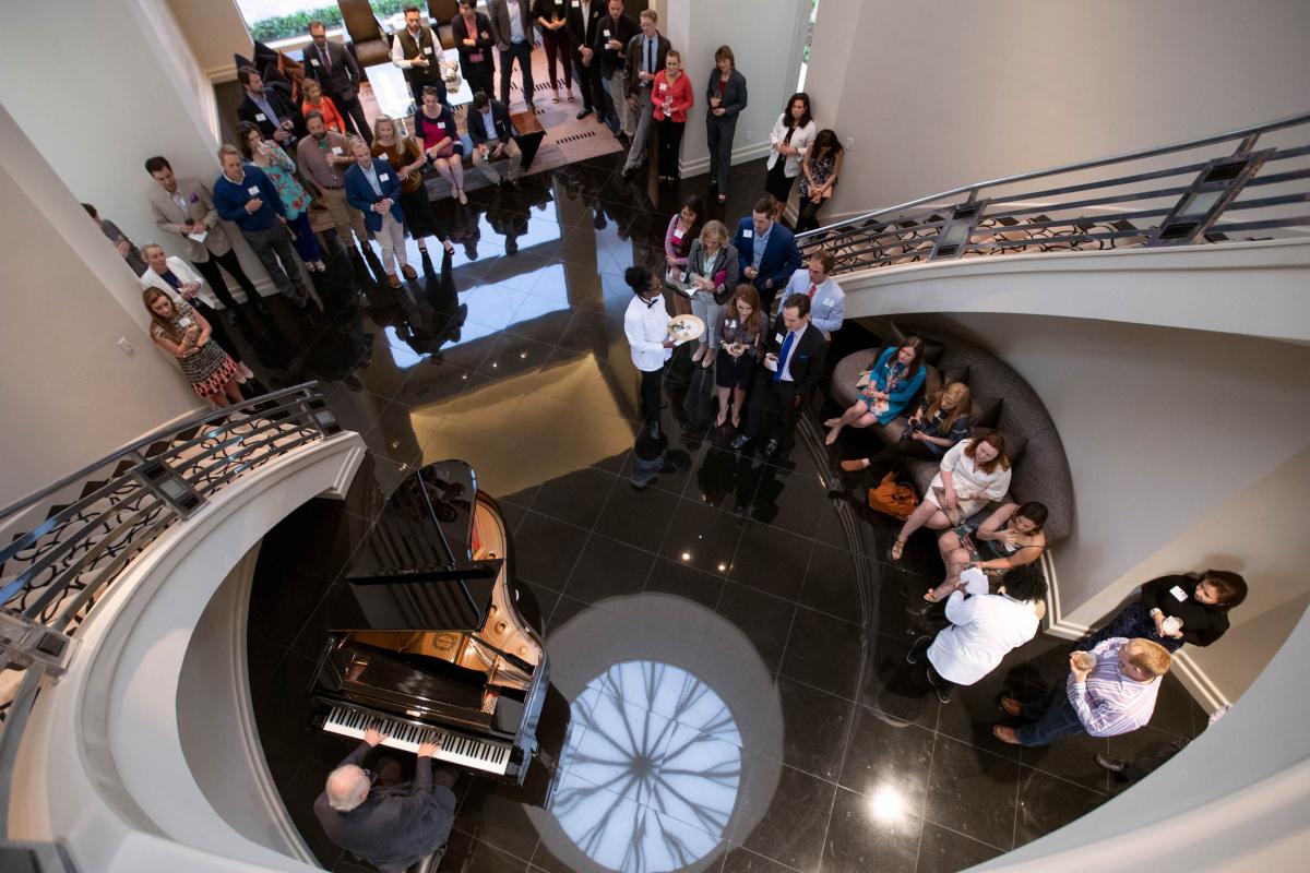 A bird's eye shot of a group of young professionals attending a party with performance by Emanual Ax