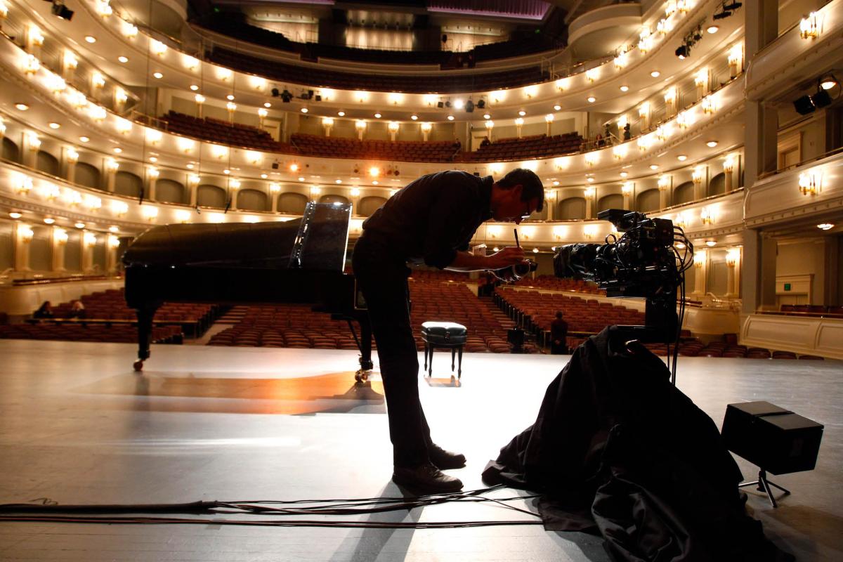 A crew member checks a camera on stage at Bass Performance Hall