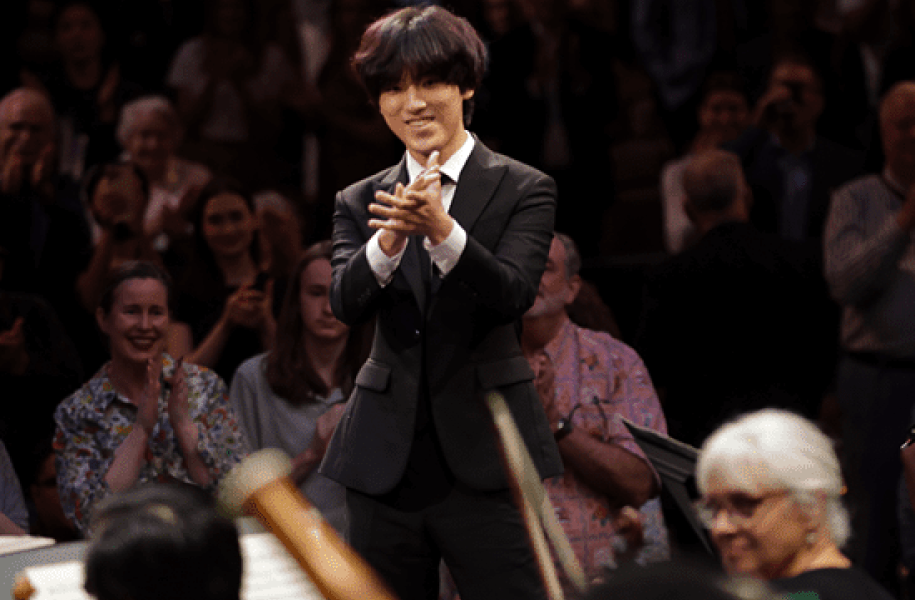 Yunchan Lim wearing a suit and clapping in front of a crowd