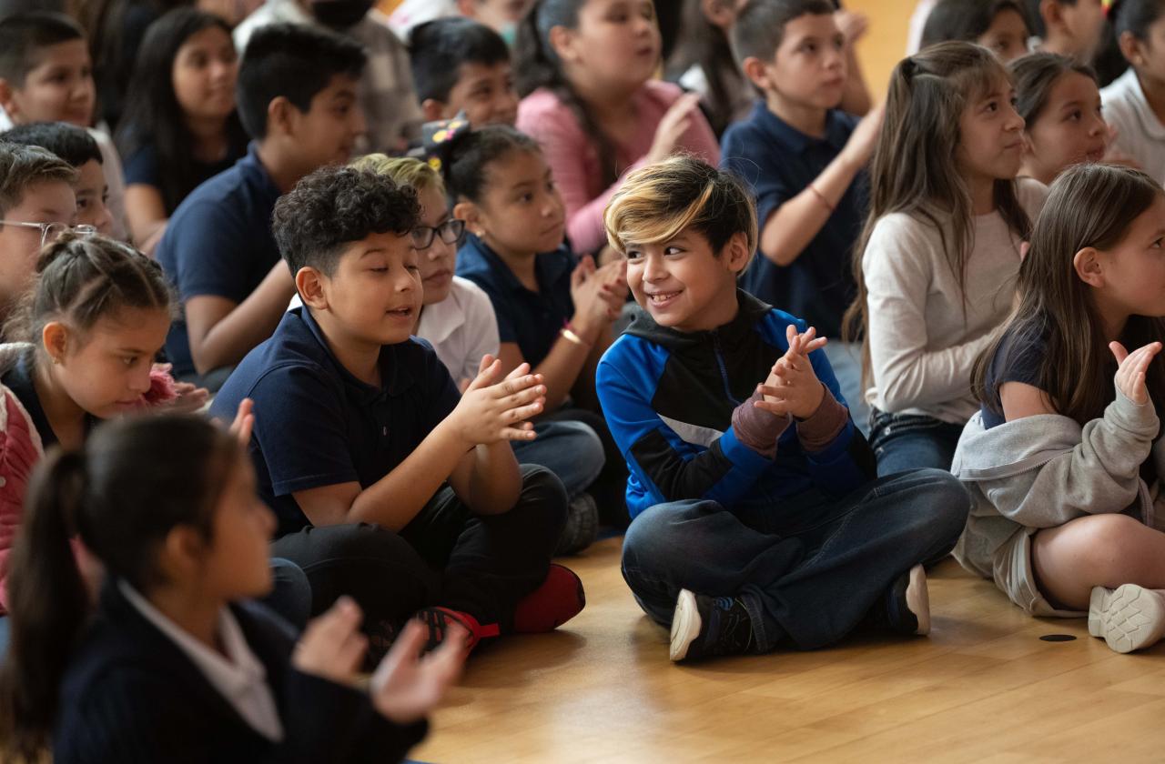Children watch a host and pianist at a Cliburn in the Classroom program